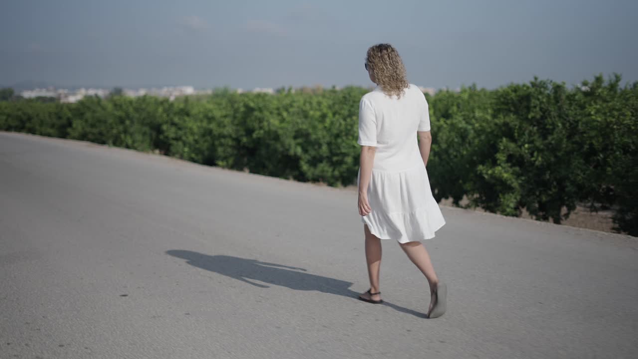 Woman walking on a road amidst trees