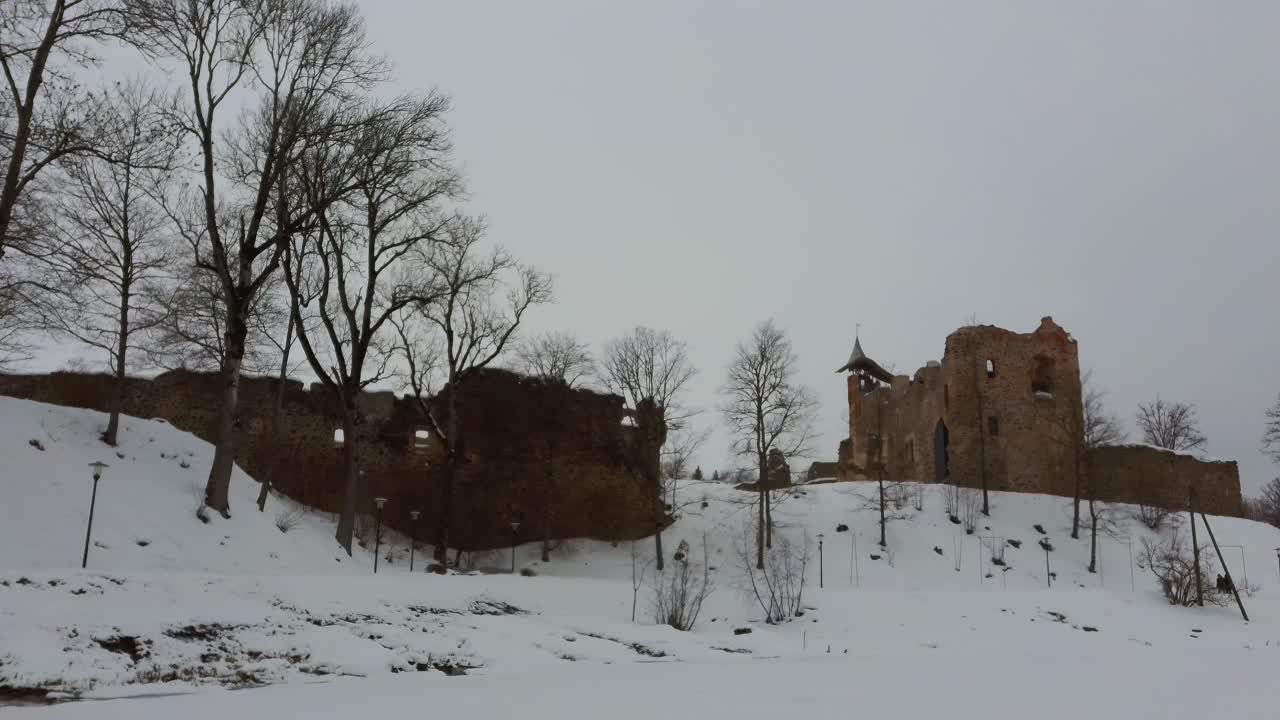 Ruins of Ancient Livonian Order's Stone Medieval Castle Latvia Aerial Drone Top Shot From Above . Restored Castle Capella at Winter in Dobele City. 4K Resolution. Camera Moves Sideward