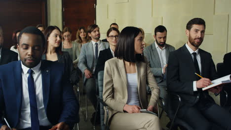 close-up view of multiethnic business people sitting on chairs and listening in a conference room