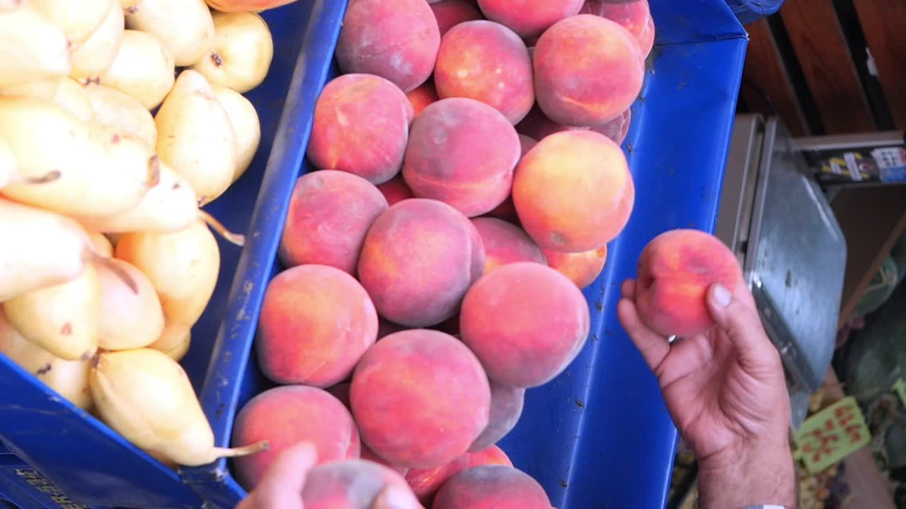 Brzoskwinie i gruszki na targu świeżych owoców