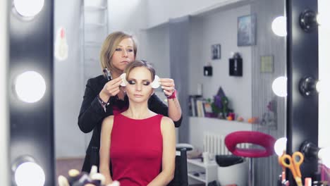 artista de maquillaje quitando parches blancos para la protección de la piel de la piel del modelo. maquillaje profesional. toma en cámara lenta