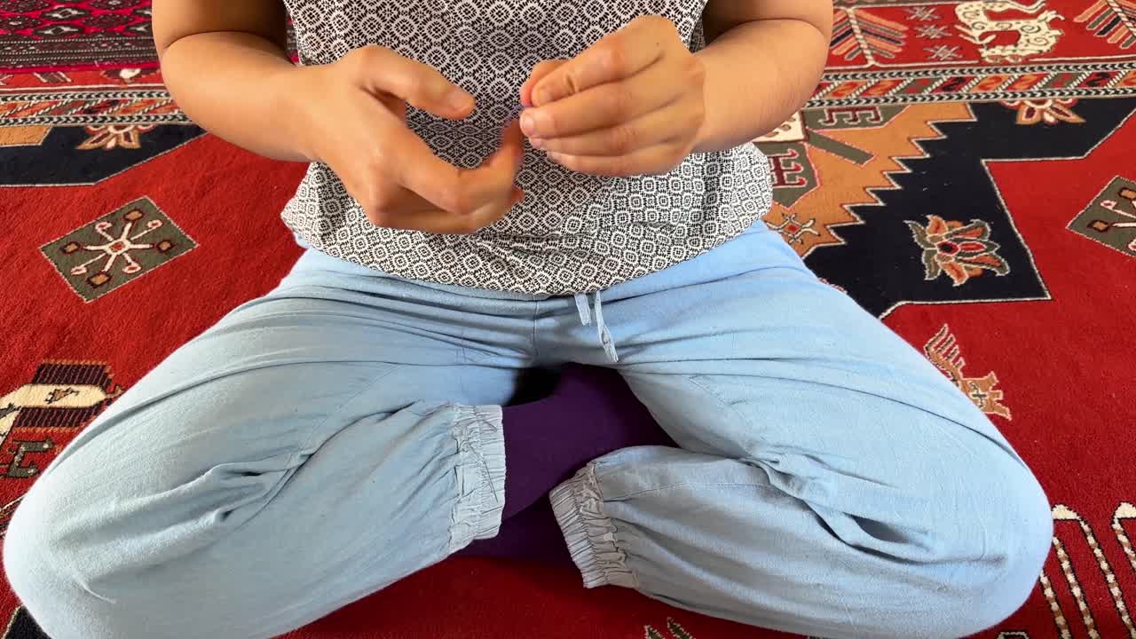 una mujer coser el tejido tejido tejido de cebra hecho a mano en casa en una alfombra persa roja para hacer cortina de confección en el área rural vida de la aldea en el medio oriente asia