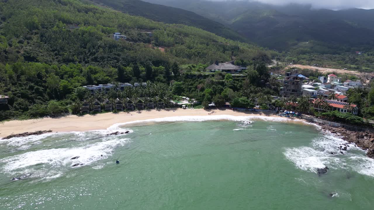 Slow drone push out over stunning tropical beach with summer resorts