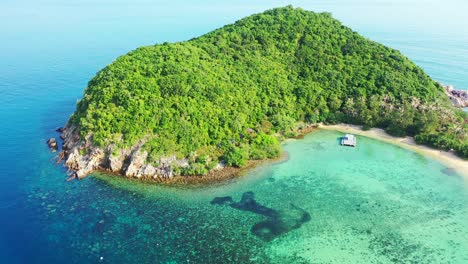 Remote-tropical-island-with-lush-vegetation-and-no-people-surrounded-by-beautiful-turquoise-lagoon-and-blue-sea,-Thailand