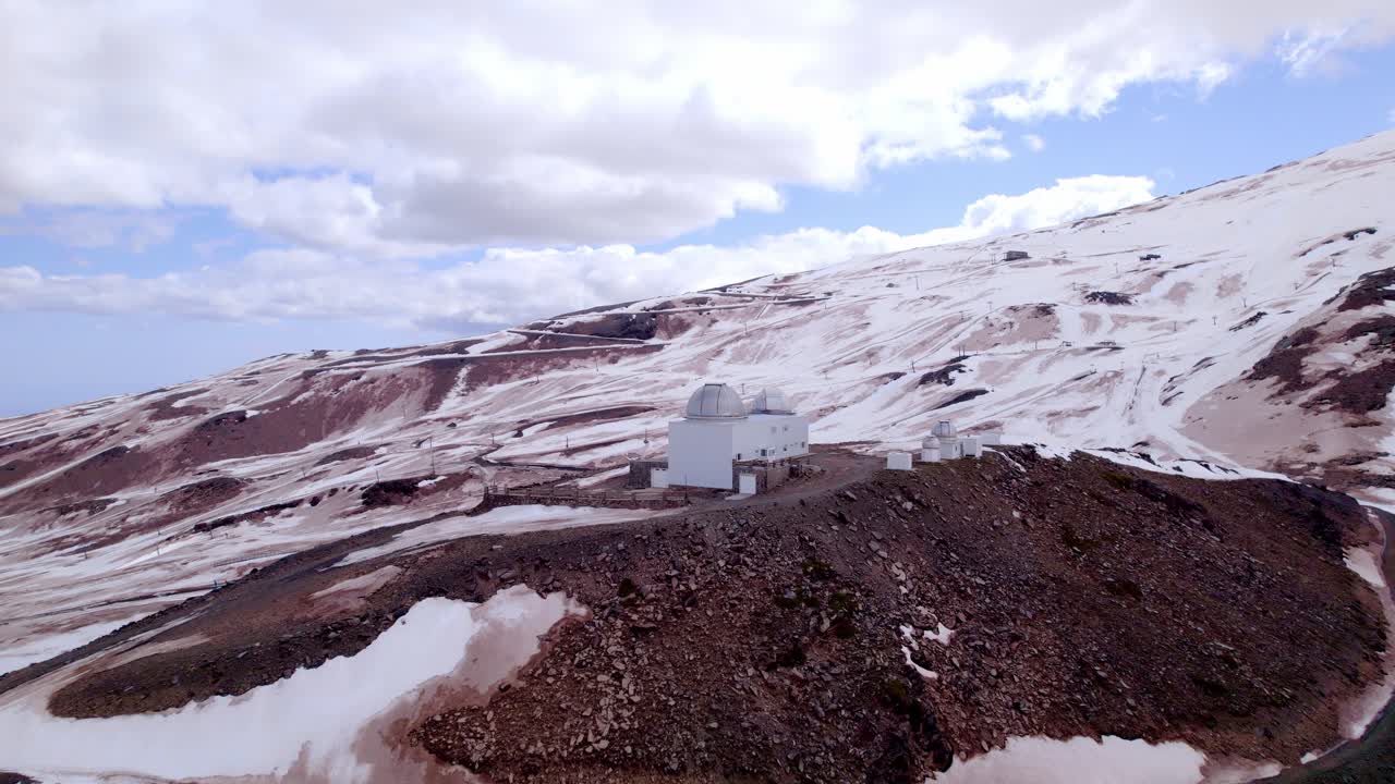 Astronomical observatory in snowy mountains. Close-up aerial view. Telescope domes in high mountains. Sierra Nevada. Spain.