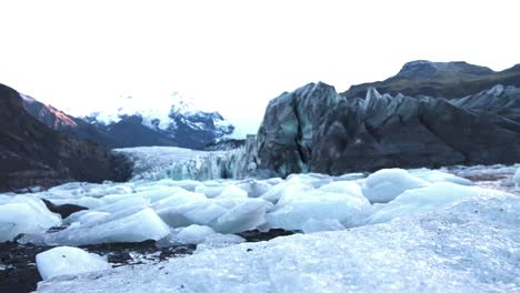 chunks of ice between rocks of skaftafell glacier in iceland at dawn