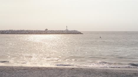 una familia de tres camina por la playa de venecia de los ángeles, ee.uu.