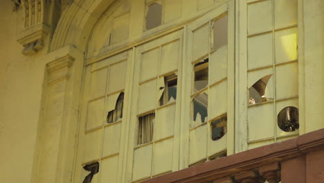 the windows of a formerly grand old building are smashed, now derelict and abandoned in colonia juárez, mexico city