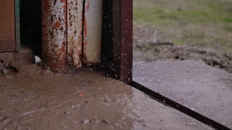 this video shows rain drops falling in a barn or garage on concrete in slow motion