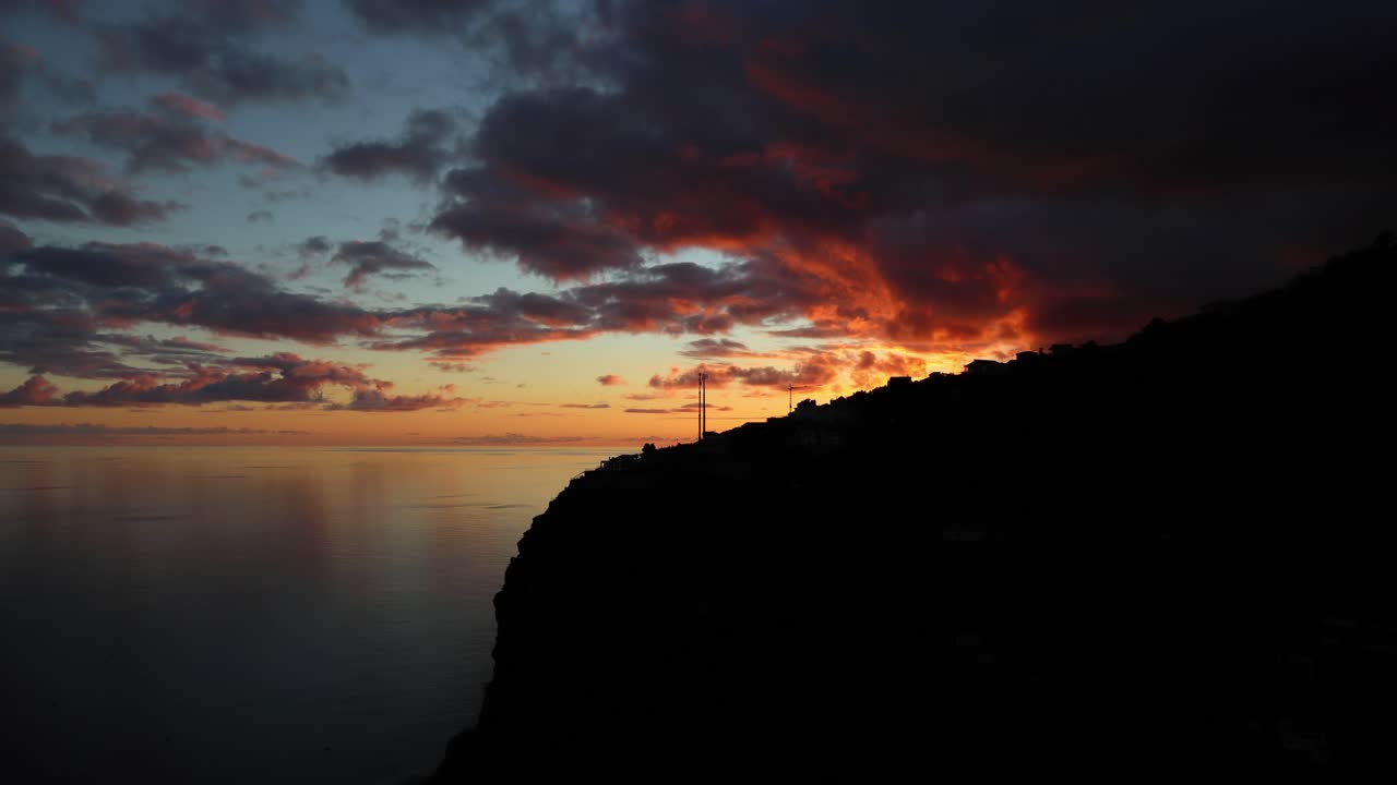 rote wolken spiegeln sich bei sonnenuntergang im ozean einer tropischen insel wider, 4k zeitraffer
