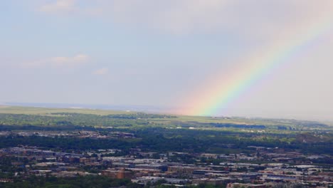 Boulder is bathed in soft post-storm light as a brilliant rainbow stretches across the sky. This moment captures nature’s beauty at its finest.