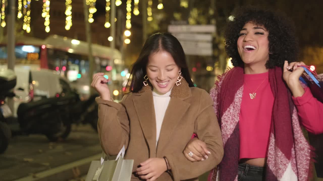 Two women shopping at night in the city