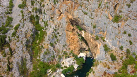 Steep-Rocky-Cliffs-With-Blagaj-Village-And-Monastery-At-Buna-River,-Mostar-Basin-In-Bosnia-and-Herzegovina