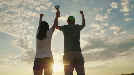 un hombre y una mujer levantan la mano con la victoria de la copa del campeón y el video de éxito en cámara lenta