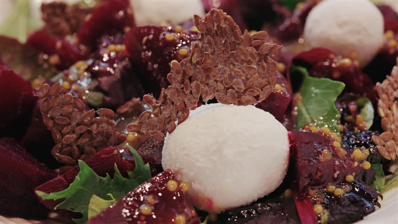 Primo piano di un'insalata di barbabietole con formaggio cremoso, semi e foglie verdi