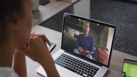 Afroamerikanische-Frau-Führt-Einen-Videoanruf-Auf-Dem-Laptop-Mit-Einem-Männlichen-Kollegen-Im-Büro