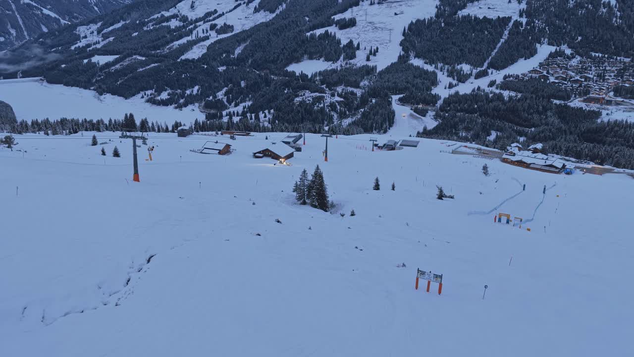 Riprese aeree con drone di battipista che preparano le piste da sci nella Zillertal Arena, Krimml e Königsleiten, Austria, con neve profonda e vista sulle montagne.