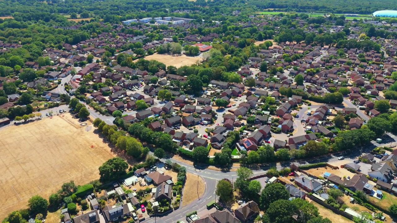 Marchwood is a Hampshire village on Southampton Water near the New Forest, featuring residential estates, local boatyards, and a major military port on sunny summers day with dry grass.