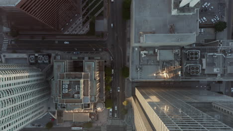 City-Birds-eye-view-of-Downtown-Los-Angeles-with-busy-car-traffic-on-street-and-Skyscraper-Rooftops,-Overhead-View