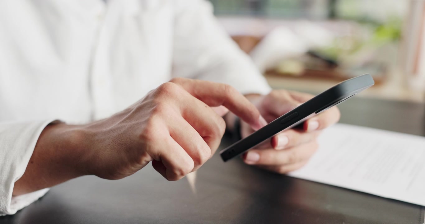 Man Using Smartphone at Desk in Office