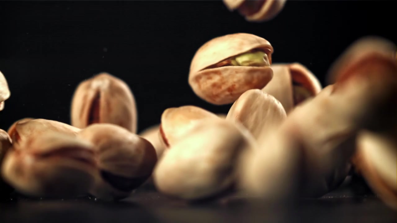 Slow Motion Pistachios Falling on a Black Background