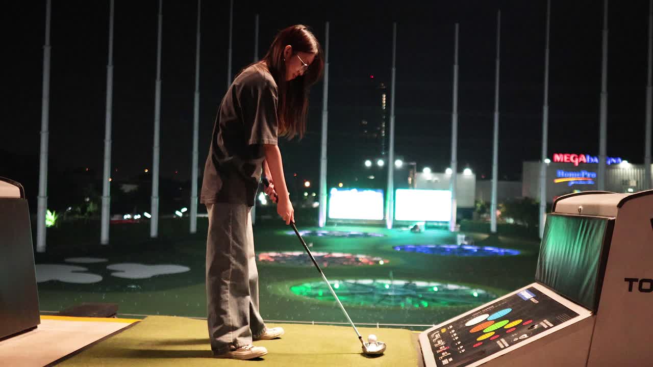 야간 경기장에서 골프 스을 연습하는 사람