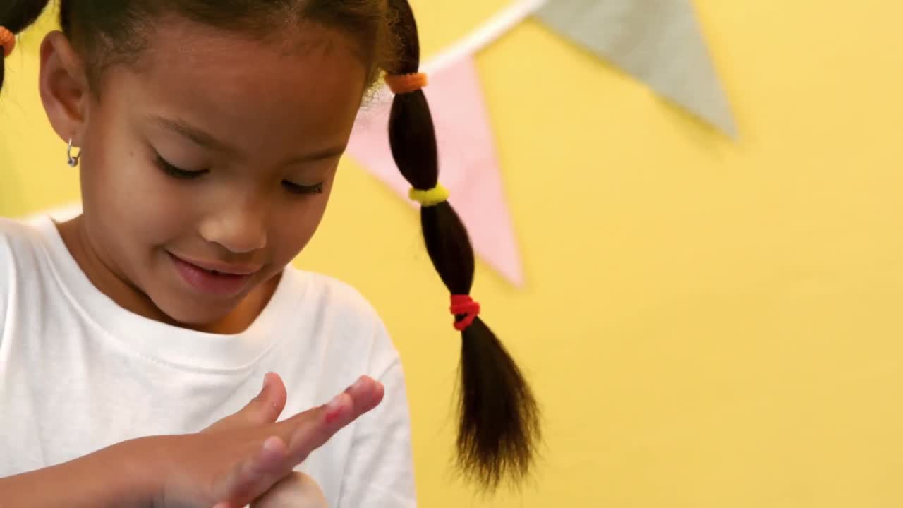 chica feliz rodando arcilla de modelado en una pelota