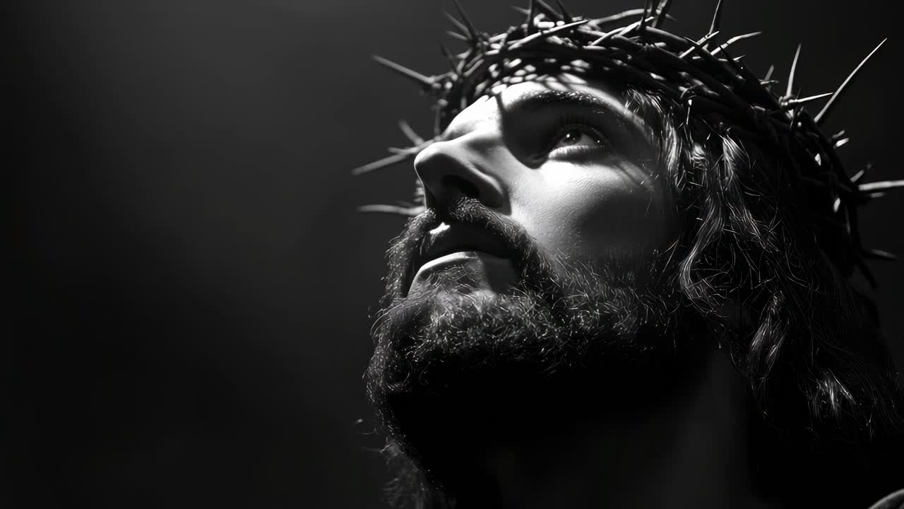 Dramatic close-up video angle of a solemn figure with a crown of thorns, in black and white
