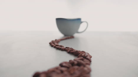 granos de café recién tostados forrados en la superficie de la taza de café
