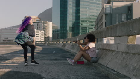 Mujer-Bailando-Joven-Bailarina-Callejera-Con-Cabello-Morado-Realizando-Movimientos-Contemporáneos-Amigos-Viendo-Tomar-Video-Usando-Un-Teléfono-Inteligente-Disfrutando-Del-Baile-Urbano-De-Estilo-Libre