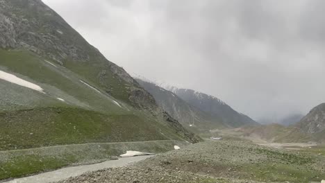 point of view of person driving near himalayan mountain ranges with people along the road during cloudy day