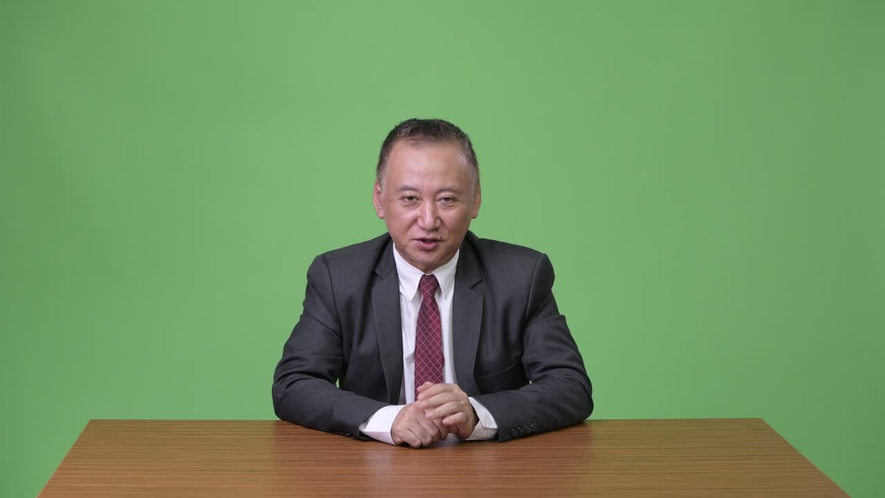 成熟した日本人のビジネスマンが何かを見せている