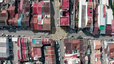 the intersection of chulia and beach streets in george town, penang island malaysia seen from above with vehicle traffic, aerial top view lowering shot