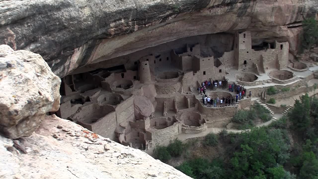 средний снимок руин скальных жилищ коренных американцев в национальном парке меса-верде