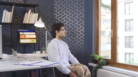 hombre de negocios discapacitado trabajando en la oficina mirando por la ventana.