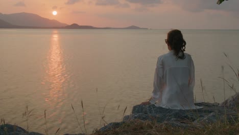 woman watching the sunset by the ocean