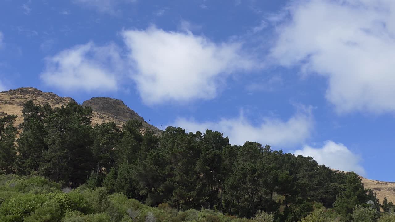 los vagones de góndola salen y llegan al destino dentro de un paisaje variado en un día soleado - mt cavendish, christchurch