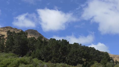 Gondola-cars-leave-and-arrive-at-destination-within-varied-landscape-on-a-sunny-day---Mt-Cavendish,-Christchurch