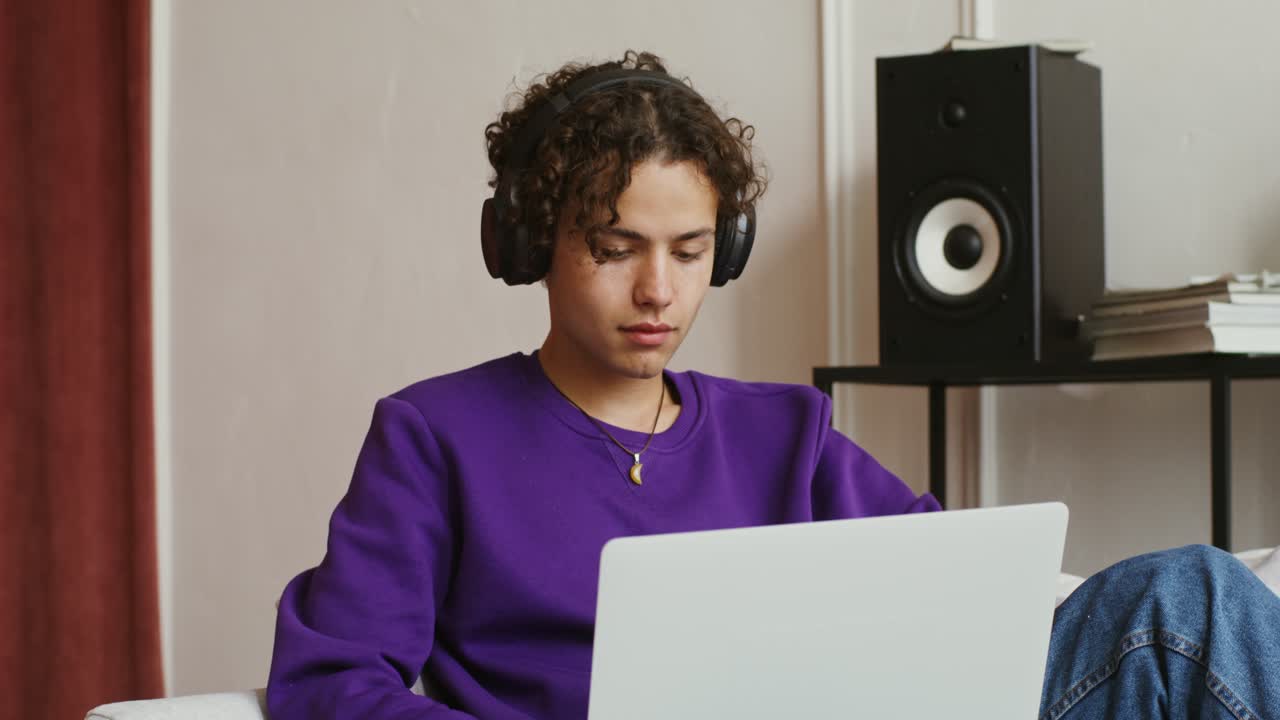 Young person studying and listening to music at home