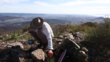 un bosquimano hierve un billy en la cima de una montaña en el país alto de victoria para hacer té de arbusto