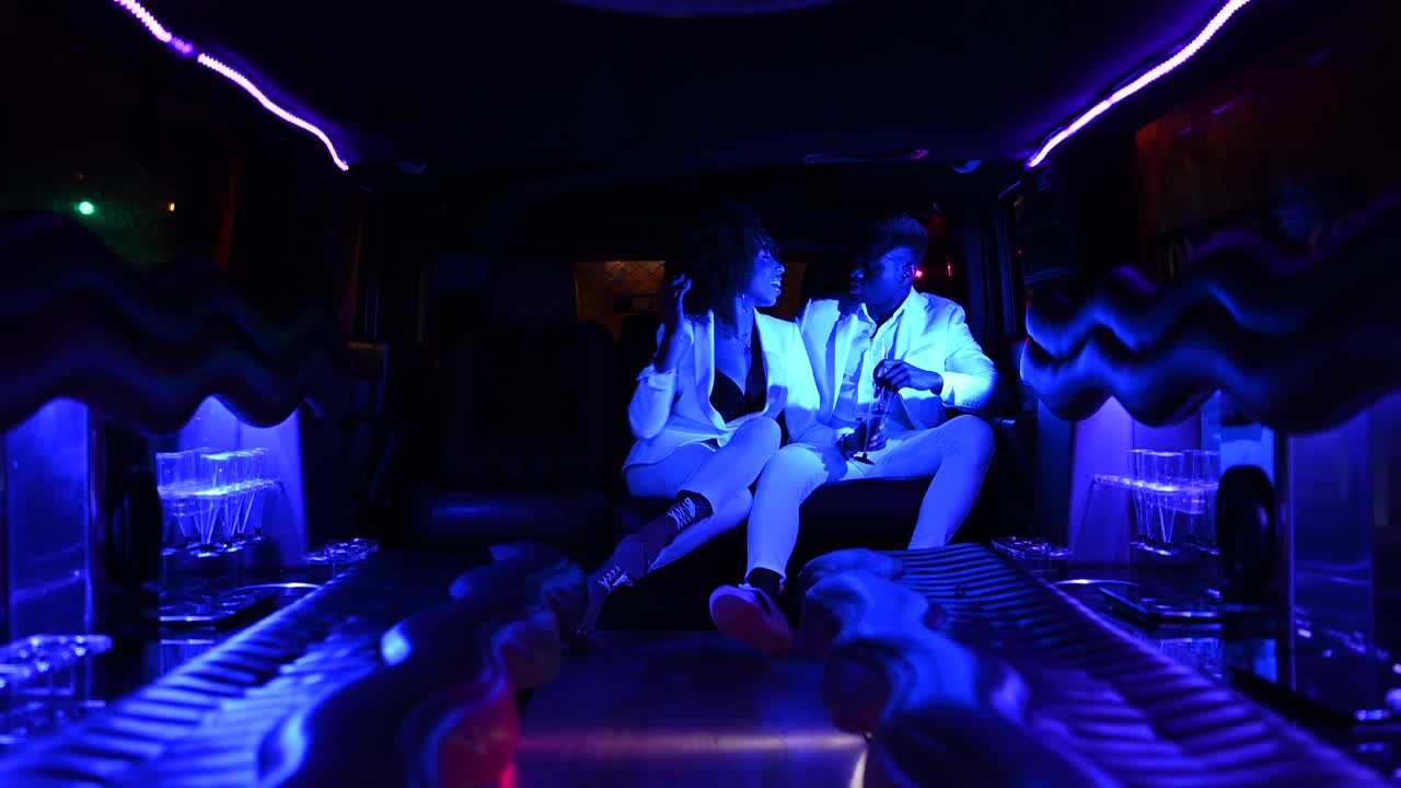 흑인 부부가 차에서  ⁇ 페인을 마시고 있습니다.