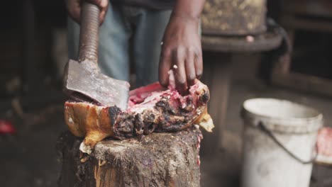 afrikanischer mann schneidet frisches fleisch