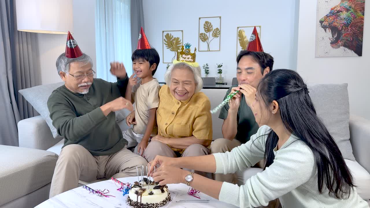 Empat generasi menikmati pesta ulang tahun yang menyenangkan, berbagi kue di ruang keluarga yang terang