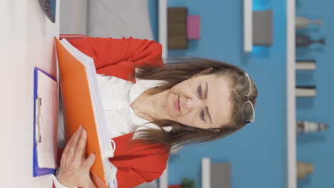 Vertical-video-of-Home-office-worker-woman-reviewing-paperwork-files.