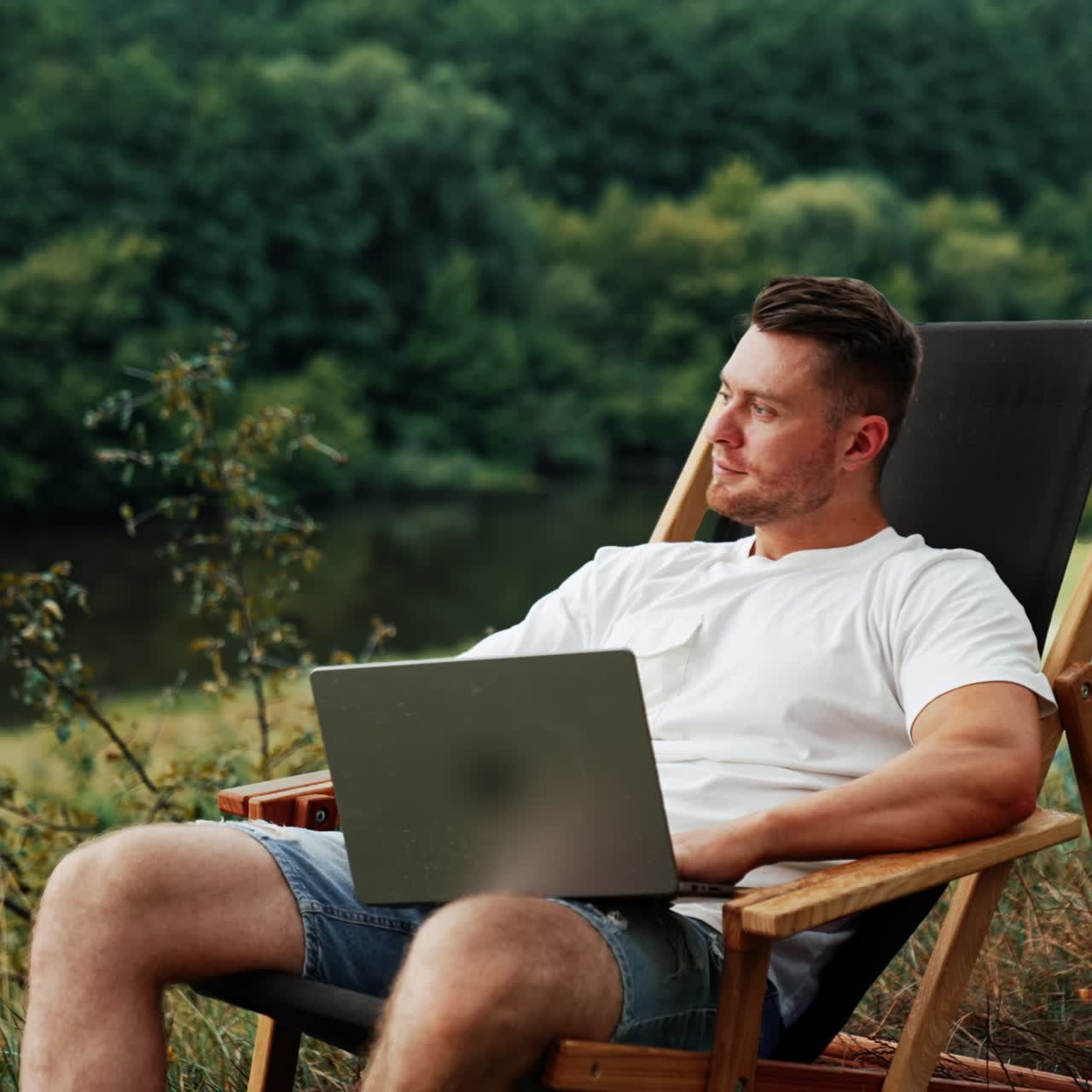 Un uomo caucasico di mezza età con la barba si distrae dal lavoro al laptop. Un uomo d'affari freelance distoglie lo sguardo, pensando a qualcosa