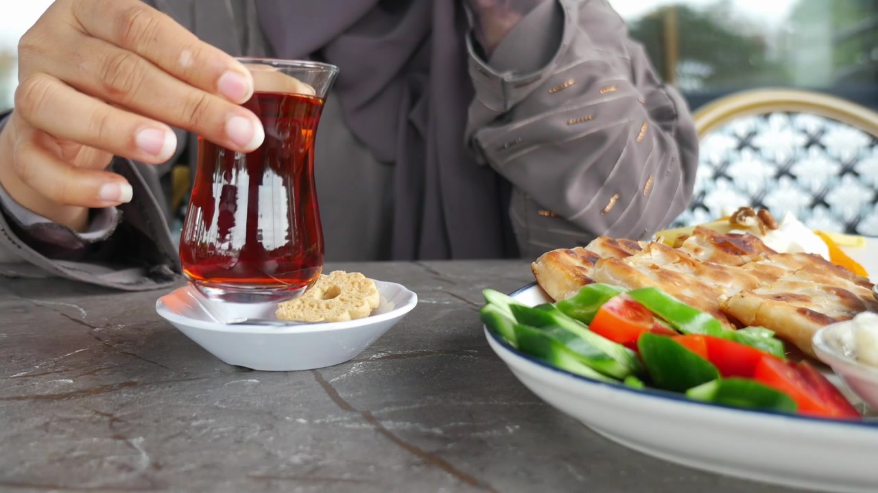 Woman in Hijab Drinking Turkish Tea During Breakfast