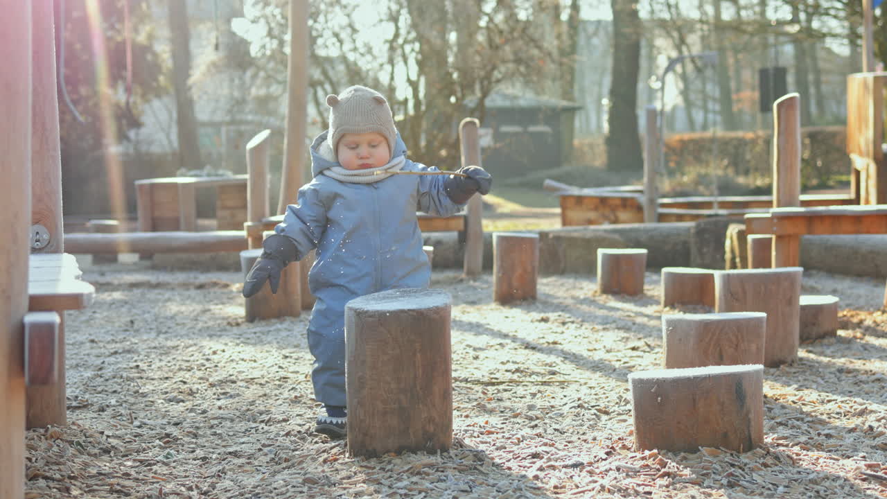 Taaperopoika talvihaalarissa leikkii ulkona leikkikentällä. Lapsi ulkoilee talvella. Talvivaatteet vauvoille.