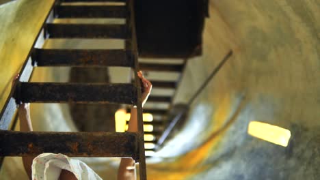 Girl-Preparing-to-Climb-Metal-Stairs-Inside-a-Tower