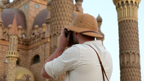 a tourist stands with a camera near the mosque,minaret.archeology