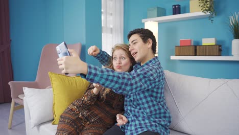 madre feliz y sonriente y hijo pequeño tomando fotos con la cámara frontal del teléfono.